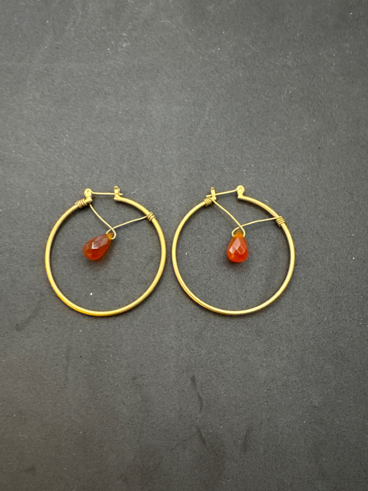 Gold tone hoop earrings with orange