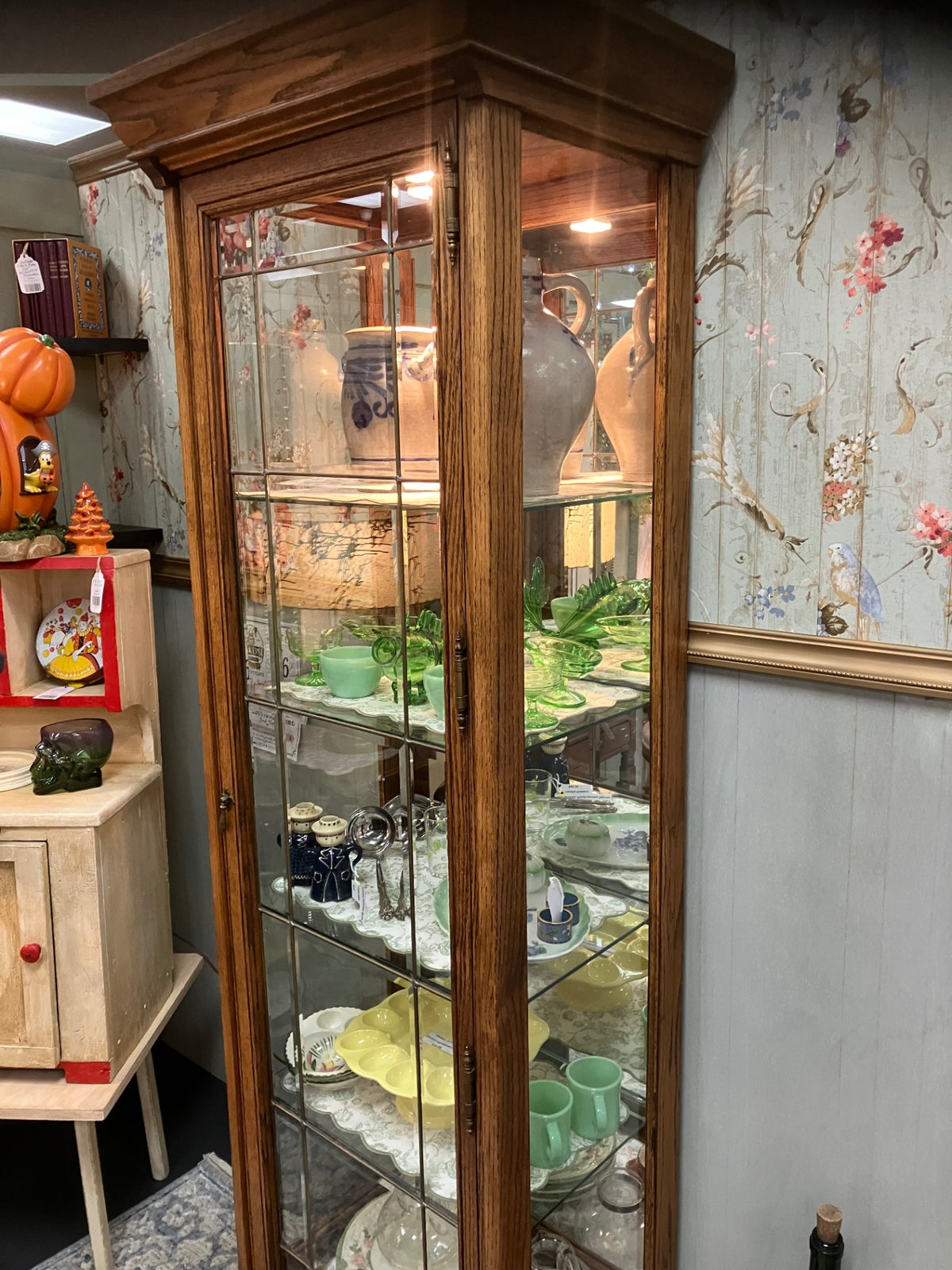 Oak lighted display cabinet with glass door and sides