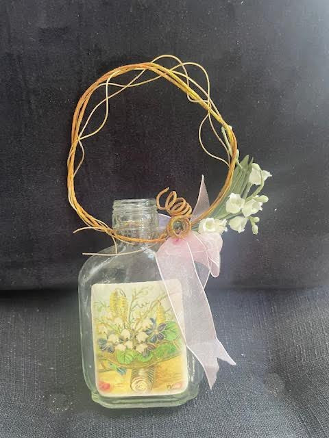 Glass bottle with vine handle and floral motif 