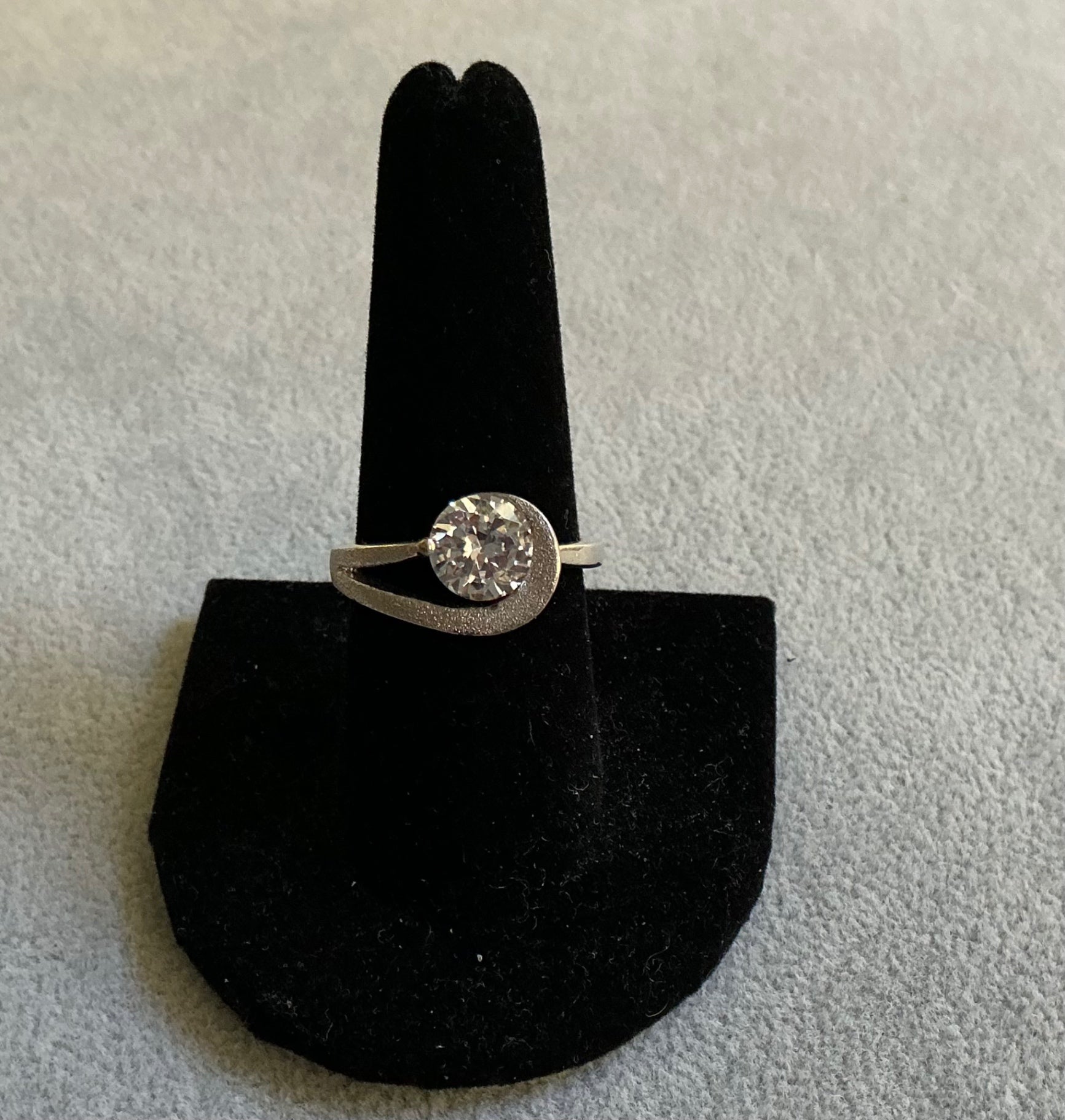 Silver- tone ring featuring a large CZ stone. 
