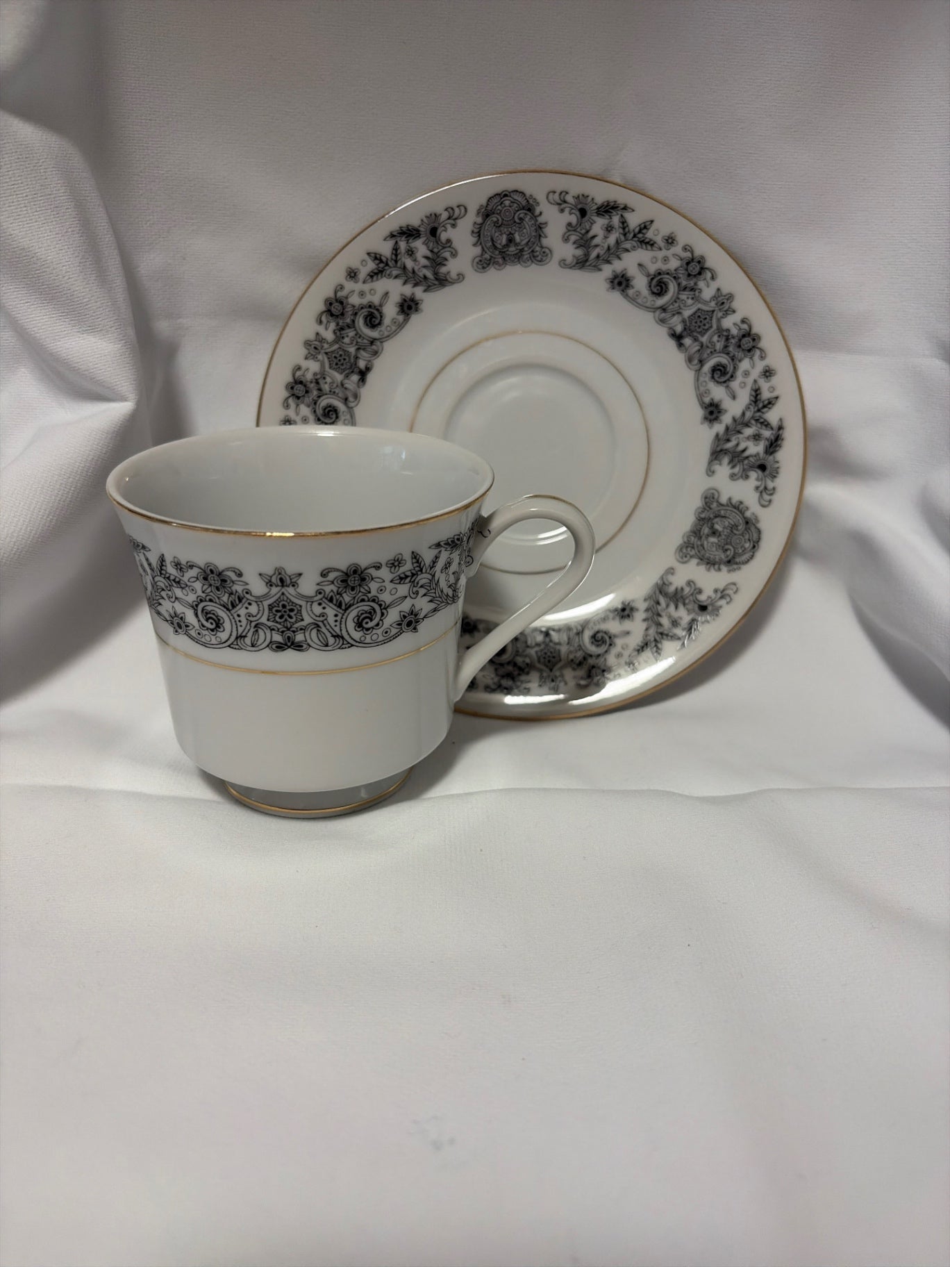 White with black floral design cup and saucer.