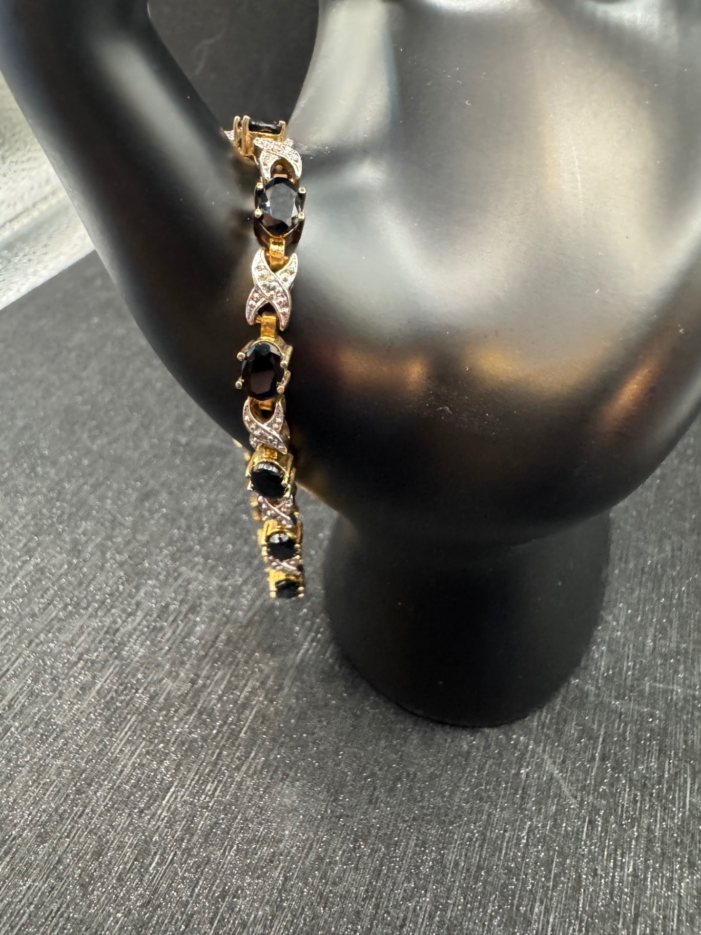 Gold tone bracelet with dark stones