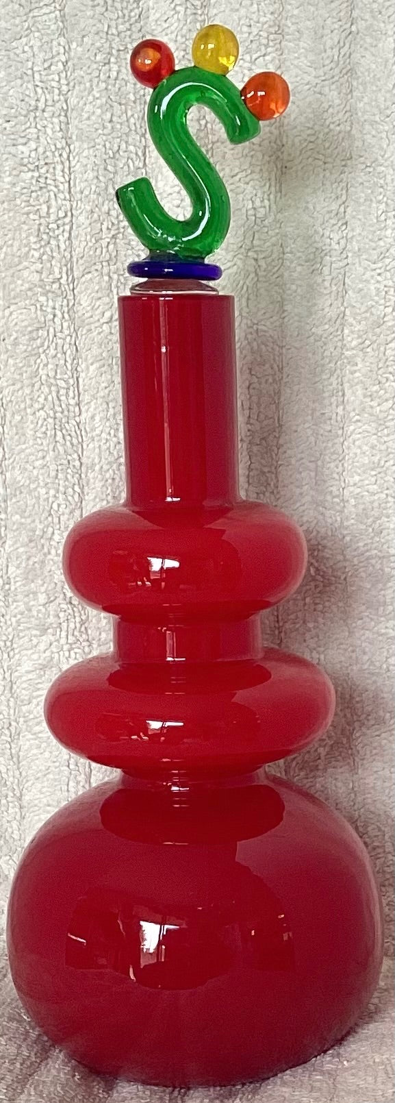 Decorative red decanter with ornate stopper
