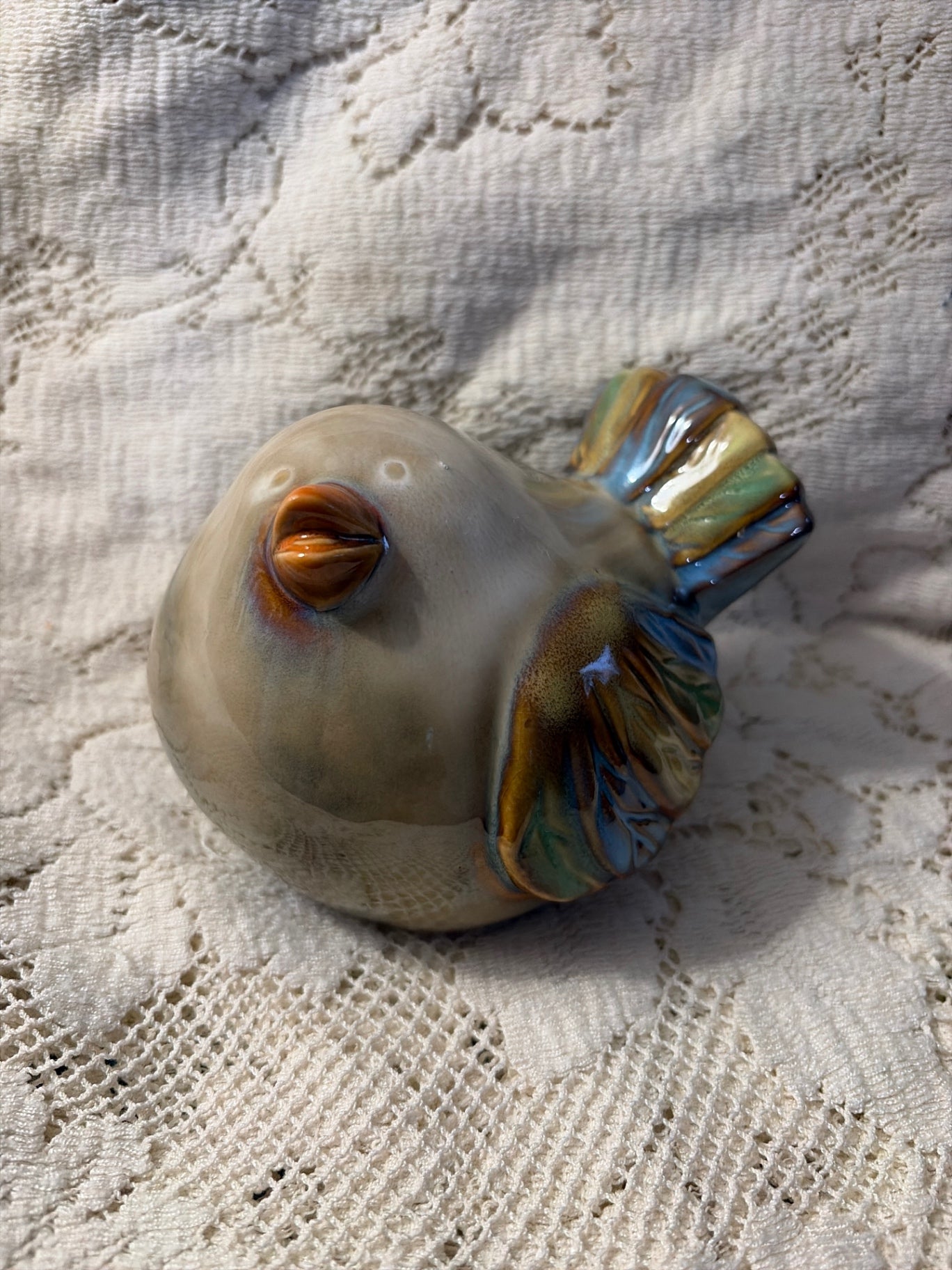 Ceramic beige bird with blue and green feathers 