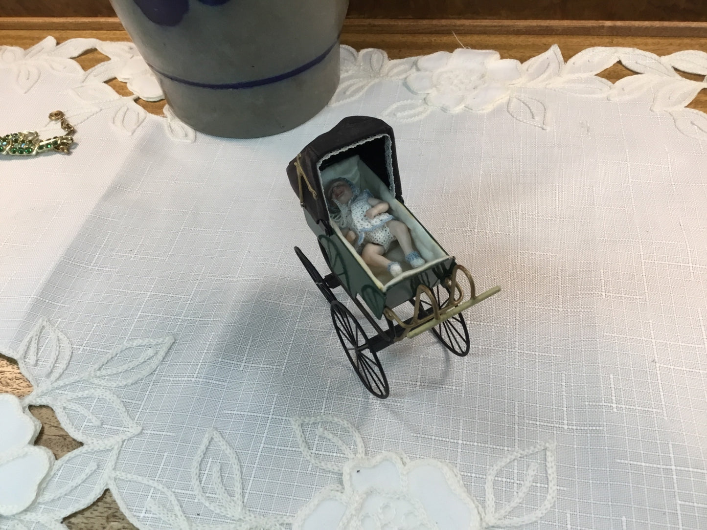 Vintage miniature metal pram with baby doll