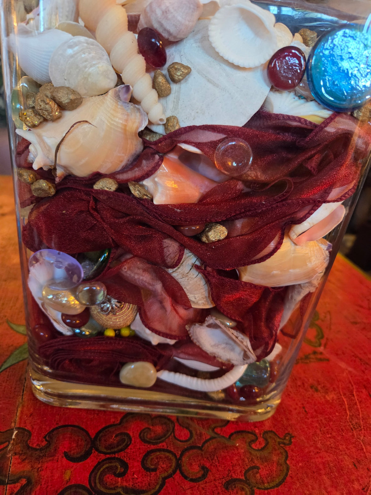 Glass vase filled with shells and treasures