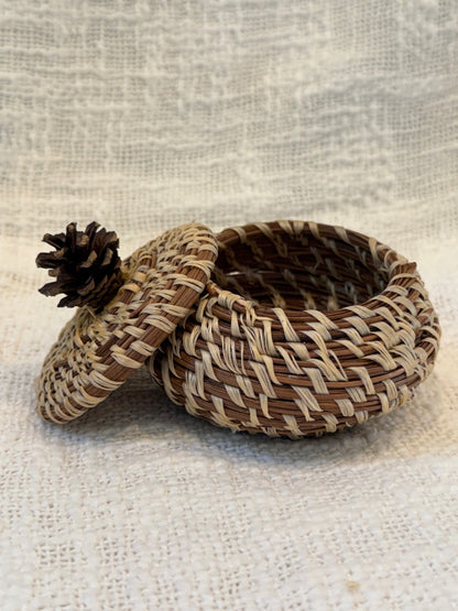 Pine needle basket with pinecone topped lid 
