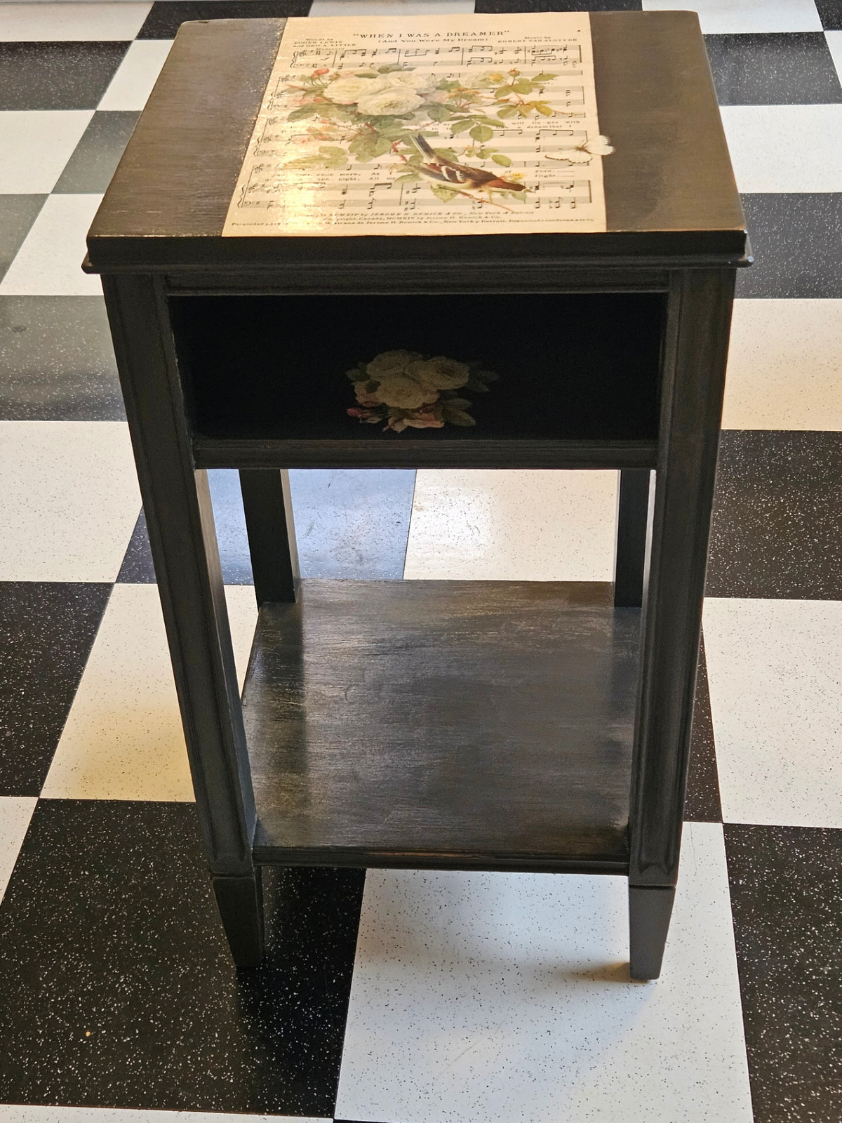 Black table w/sheet music and roses 27" high. Top 14"sq approx